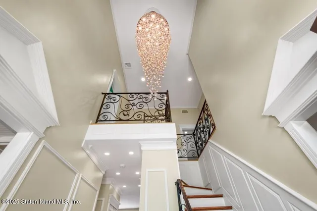 a view of empty room with wooden floor and chandelier
