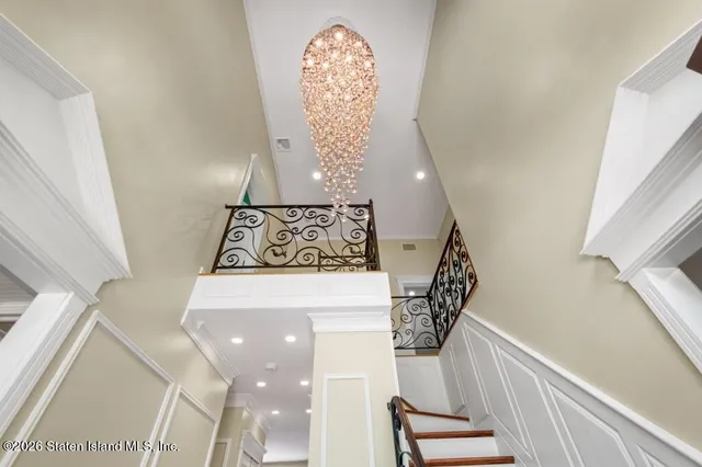 a view of empty room with wooden floor and chandelier