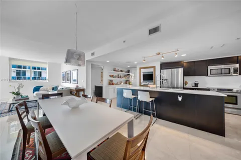 a view of living room kitchen with stainless steel appliances cabinets