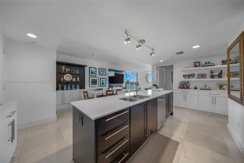 a kitchen with a sink a counter top space appliances and cabinets
