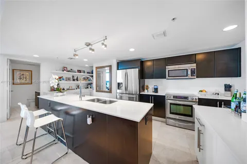 a kitchen with stainless steel appliances a stove microwave and sink