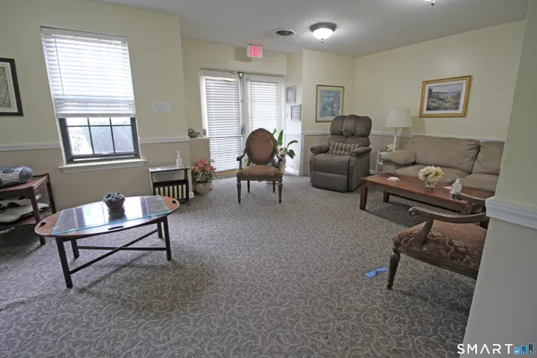 a living room with furniture a flat screen tv and kitchen view
