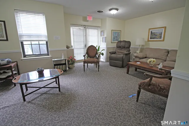 a living room with furniture a flat screen tv and kitchen view
