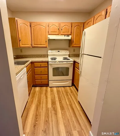 a kitchen with a white stove and refrigerator