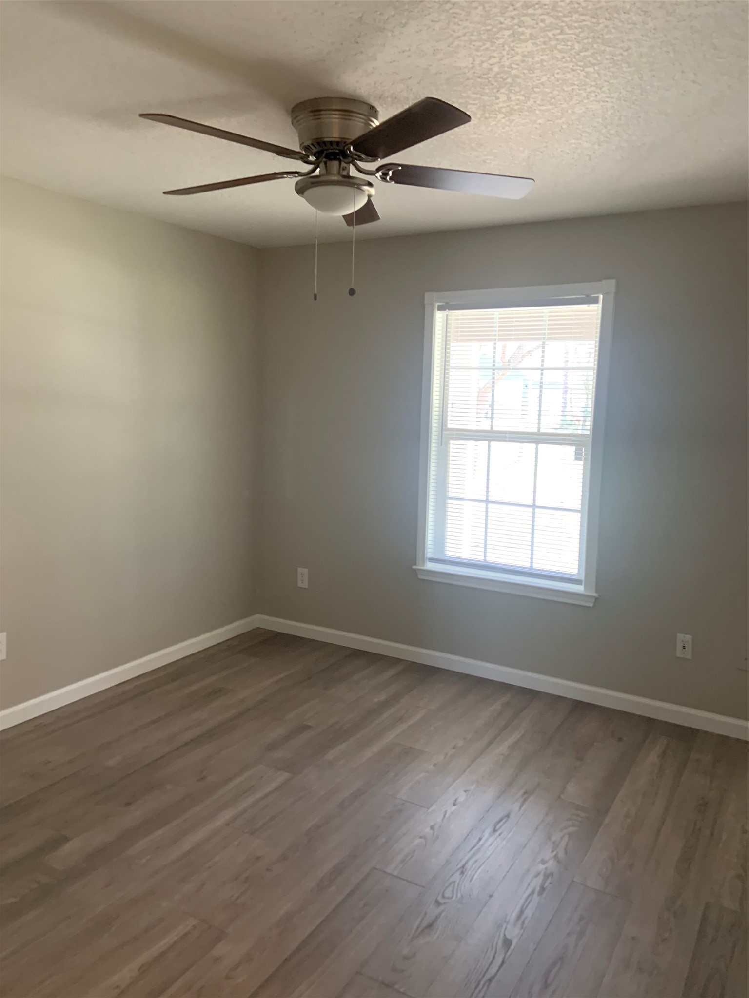 10978 Youpon Street Cleveland, TX 77328 - Photo 13 of 24 an empty room with wooden floor fan and windows
