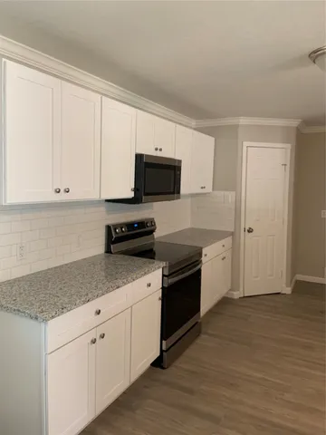 a kitchen with stainless steel appliances granite countertop a stove a sink and a microwave