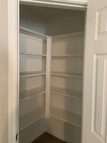 a view of walk in closet with empty racks
