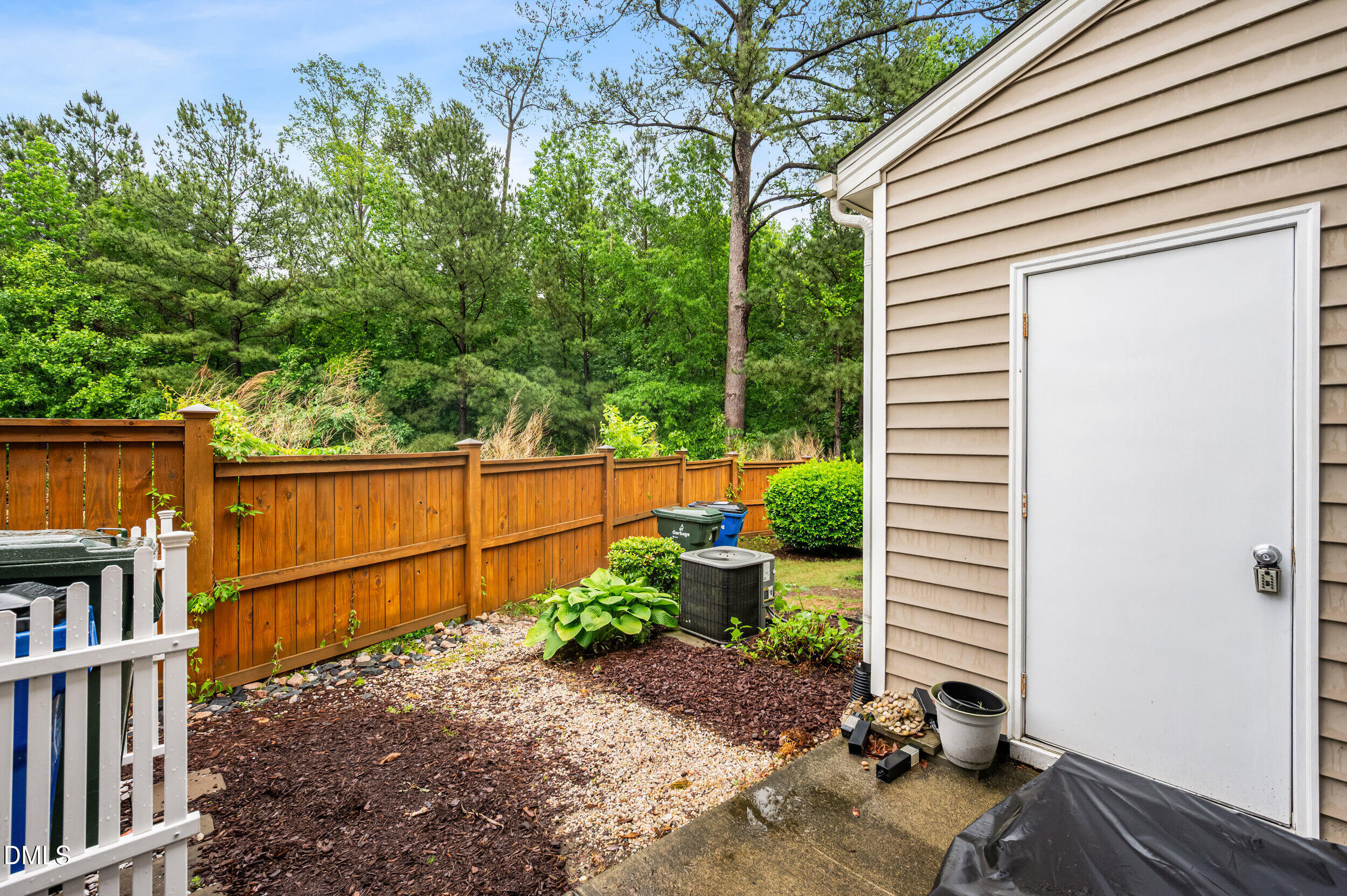 2944 Casona Way Raleigh, NC 27616 - Photo 21 of 24 a backyard of a house with plants and wooden fence