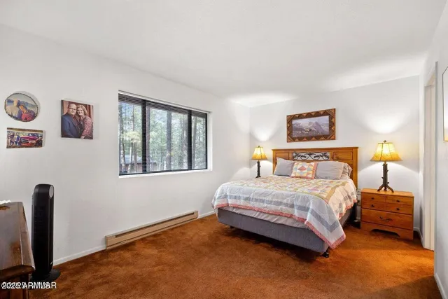 a bedroom with a bed and dresser with mirror