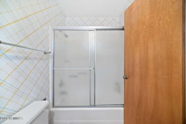 a bedroom with a bed lamp and paintings on the wall