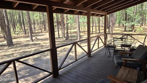 a view of a porch with furniture and wooden floor
