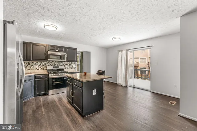a kitchen with stainless steel appliances a stove top oven and refrigerator