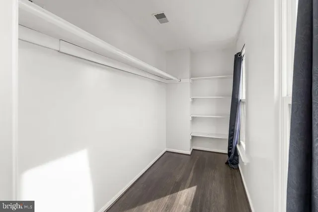 a view of walk in closet with empty racks