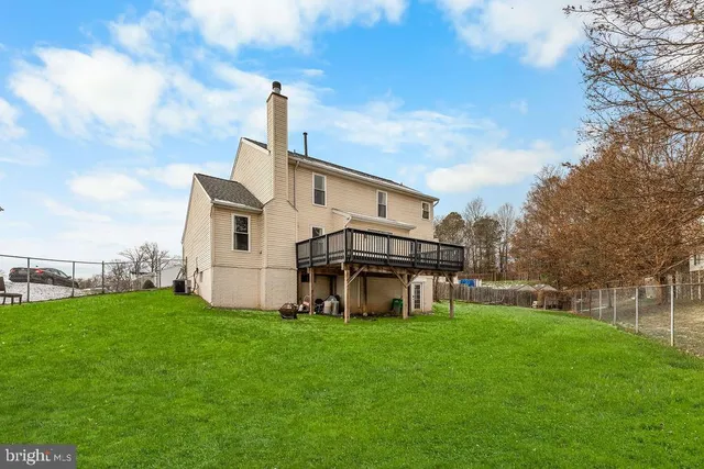 a view of a house with a big yard and large trees