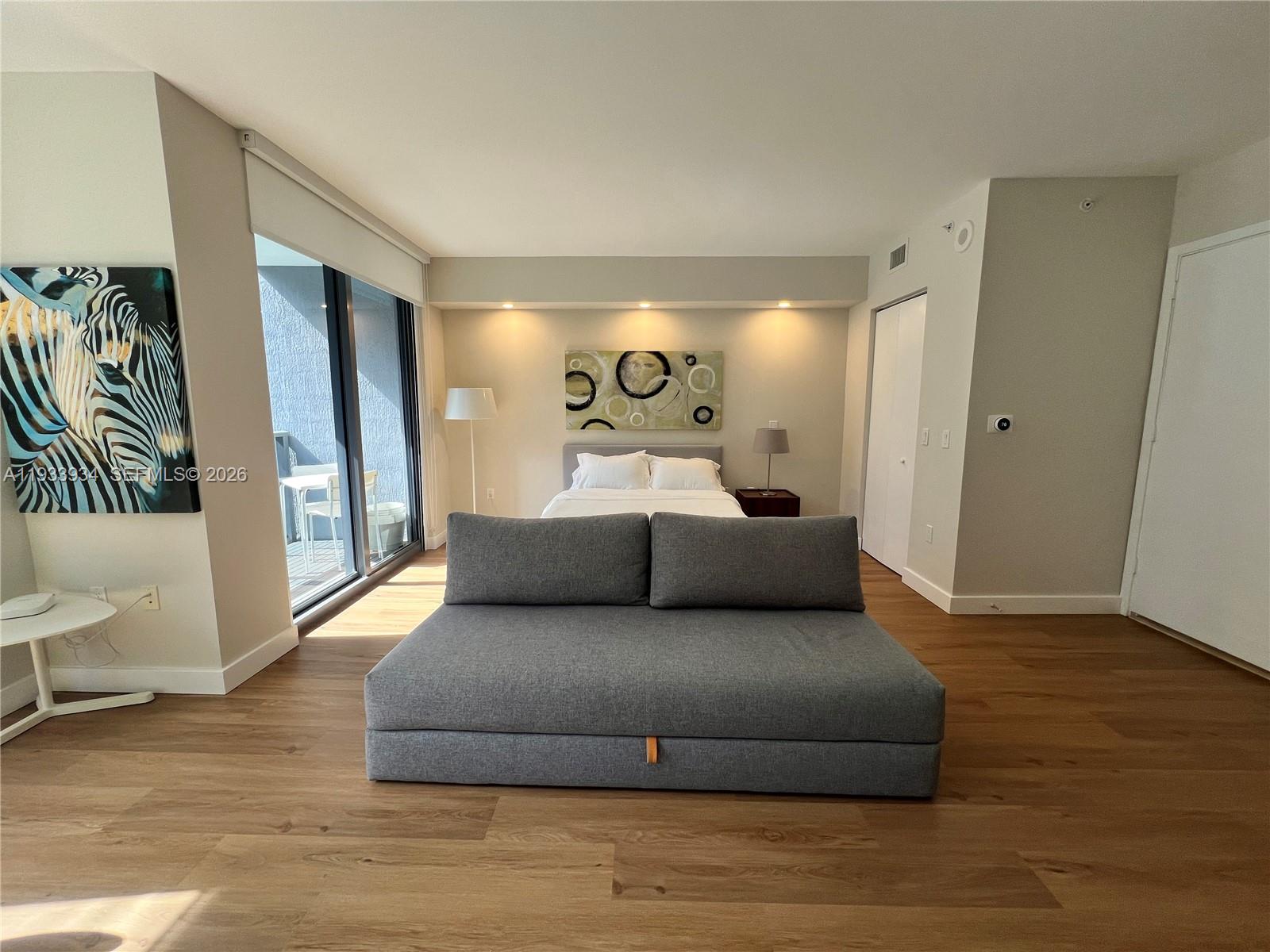 31 Southeast 6th Street, Unit 703 Miami, FL 33131 - Photo 6 of 16 a living room with furniture and a wooden floor