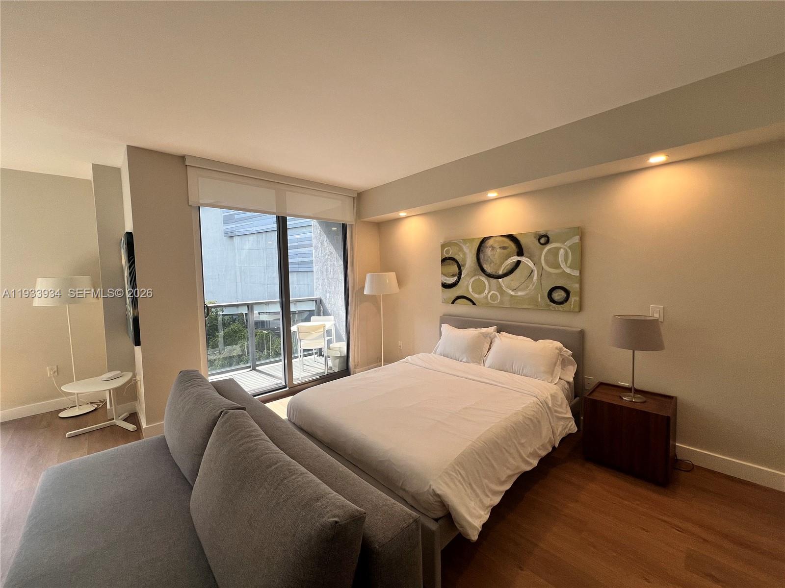 31 Southeast 6th Street, Unit 703 Miami, FL 33131 - Photo 7 of 16 a bedroom with a bed and a large window