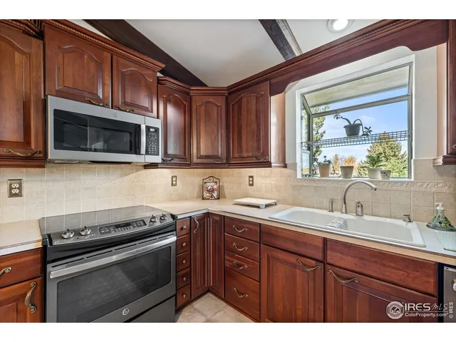 a kitchen with stainless steel appliances a sink stove and microwave