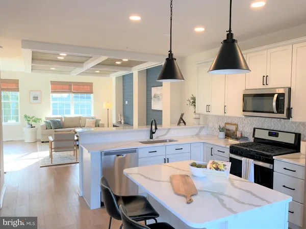 a kitchen with stainless steel appliances granite countertop a stove a sink a microwave a center island and furniture