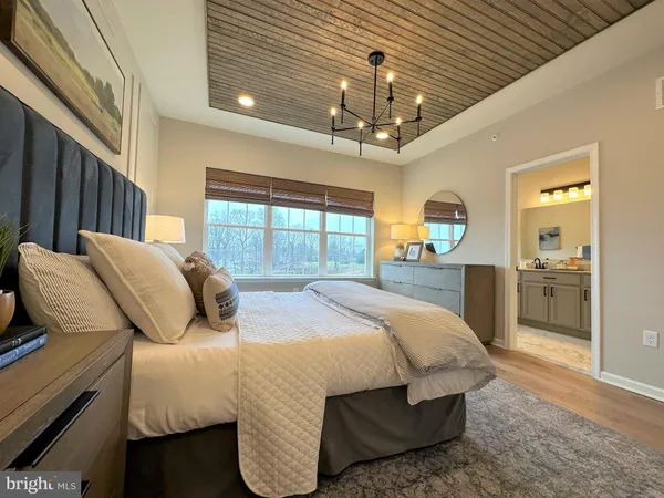 a bedroom with a large bed and a chandelier