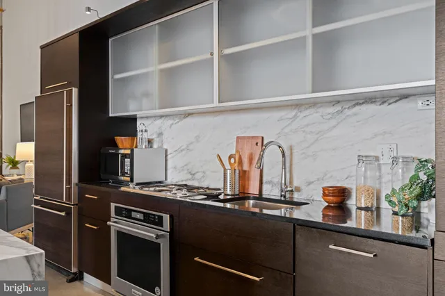 a kitchen with stainless steel appliances granite countertop a refrigerator and a stove
