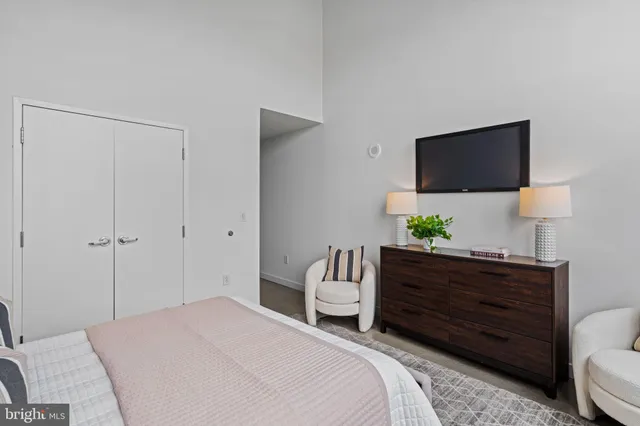 a bedroom with a bed window and a flat screen tv