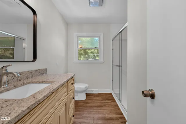 a bathroom with a granite countertop sink toilet and shower