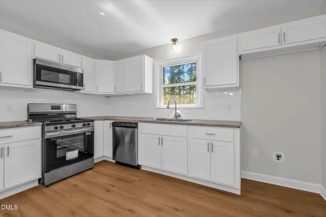 a view of a room with wooden floor and windows