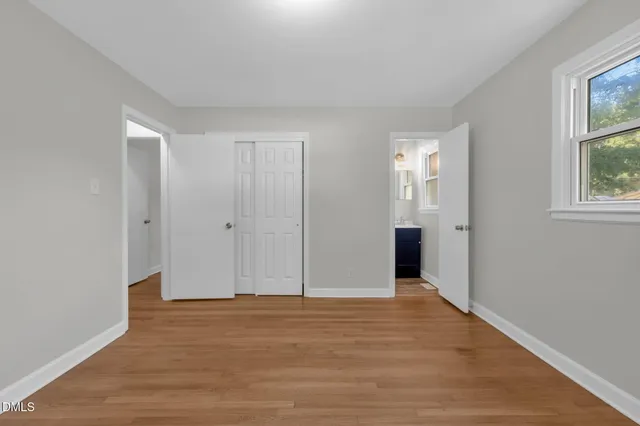 a view of empty room with wooden floor and ceiling fan