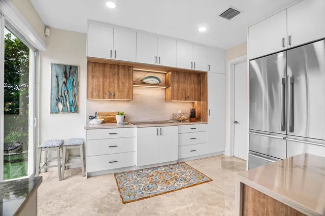 a kitchen with granite countertop a sink window and cabinets