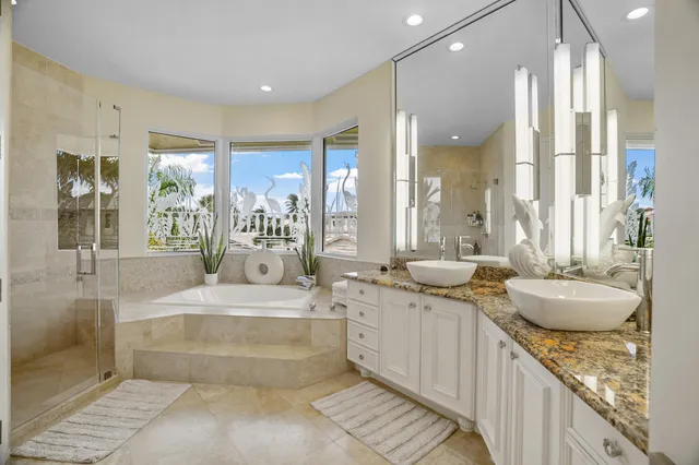 a large white bathroom with a tub and shower
