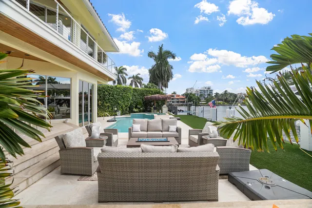 a view of a patio with couches table and chairs and potted plants