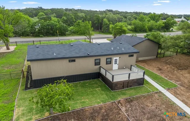 a view of a house with a backyard and a tub