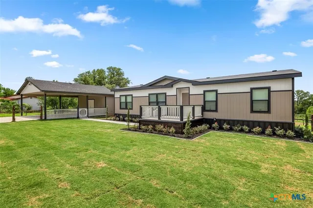a view of a house with a yard and sitting area