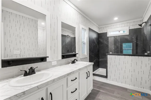 a bathroom with double vanity sink and a mirror