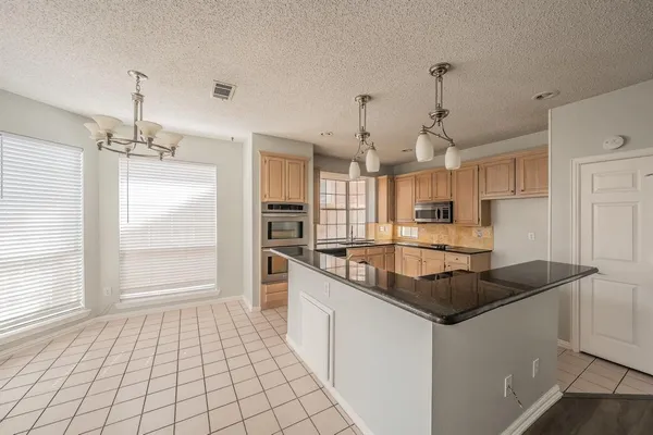 a kitchen with stainless steel appliances granite countertop a sink and a refrigerator