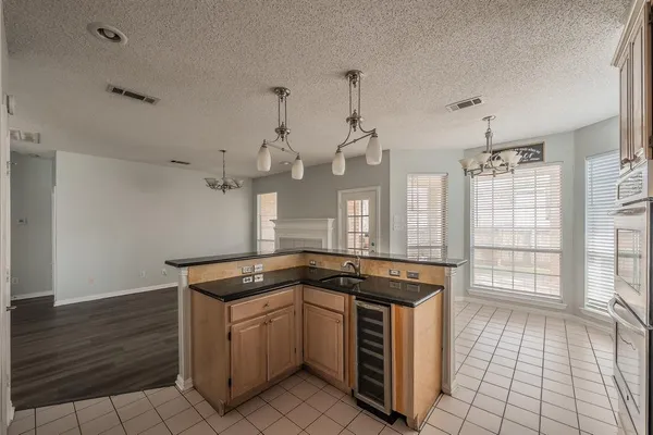 a kitchen with granite countertop a sink a stove and cabinets