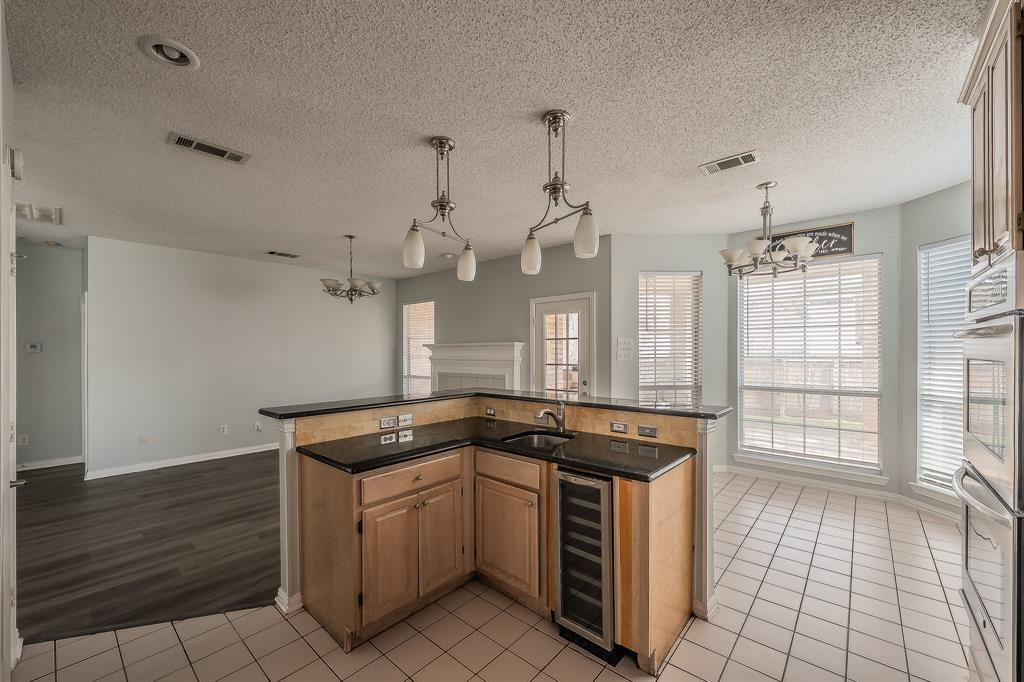 2643 Garden Ridge Lane Arlington, TX 76006 - Photo 12 of 40 a kitchen with granite countertop a sink a stove and cabinets