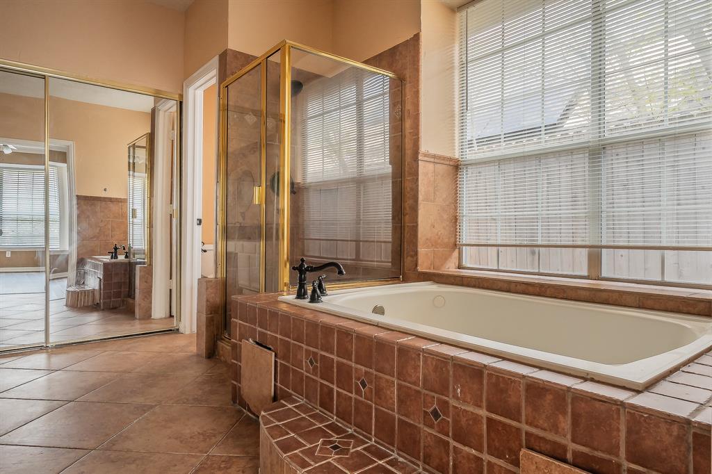 2643 Garden Ridge Lane Arlington, TX 76006 - Photo 23 of 40 a bathroom with a tub and a shower