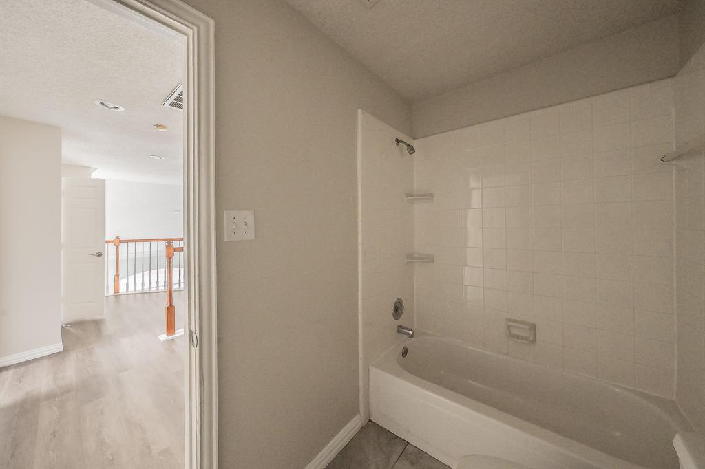 2643 Garden Ridge Lane Arlington, TX 76006 - Photo 32 of 40 a bathroom with a bathtub and a shower