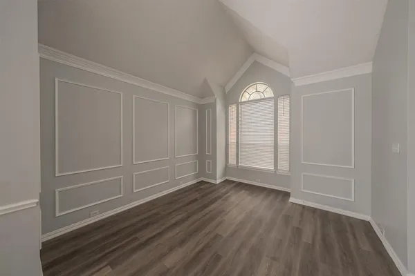 a view of empty room with wooden floor and window