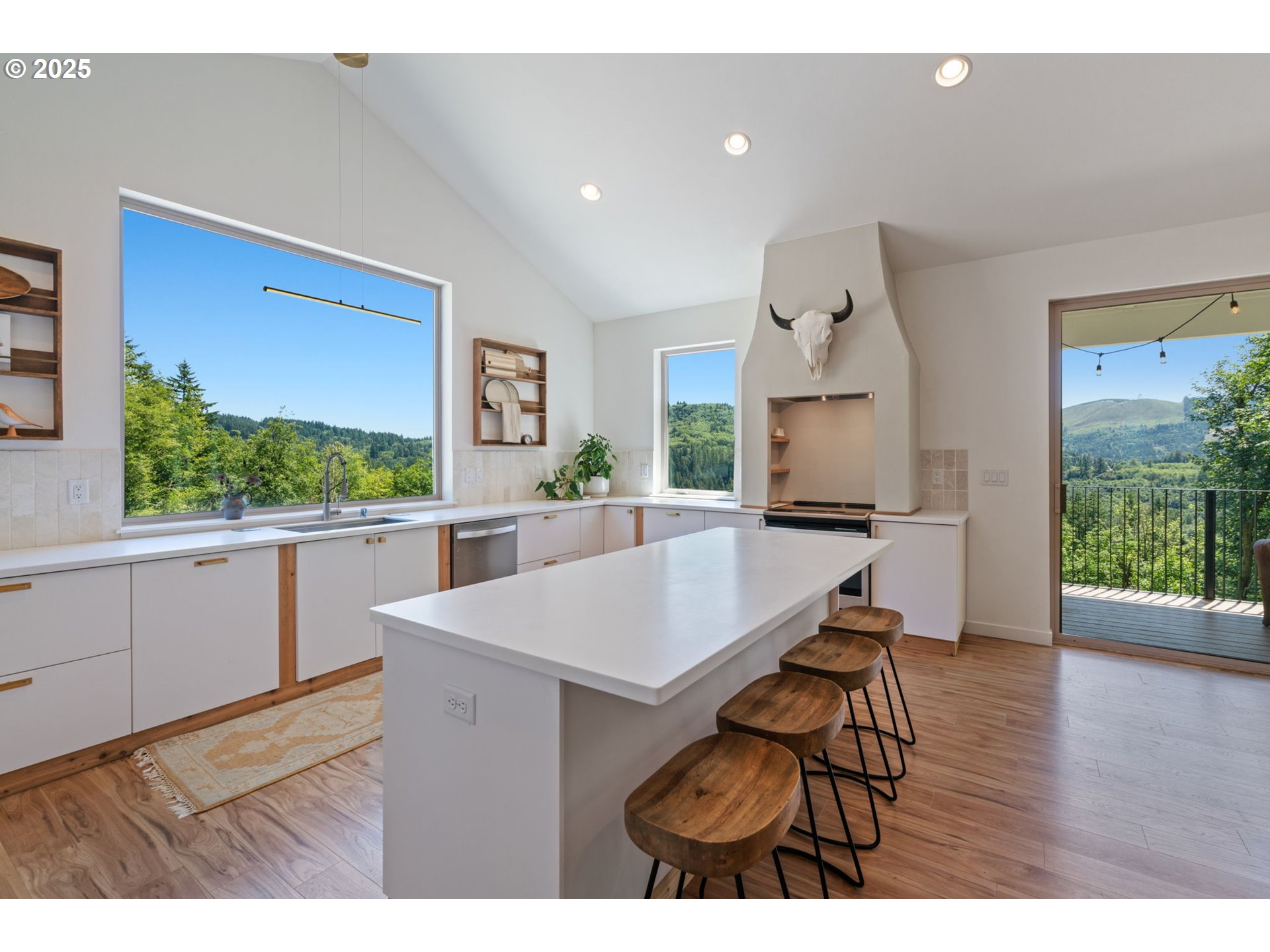 5601 Lewis River Road Ariel, WA 98603 - Photo 11 of 48 a kitchen with stainless steel appliances a kitchen island wooden floors and white cabinets