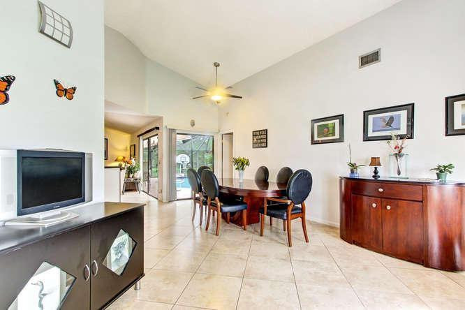 22682 Pickerel Circle Boca Raton, FL 33428 - Photo 8 of 20 a living room with furniture a dining table and a flat screen tv