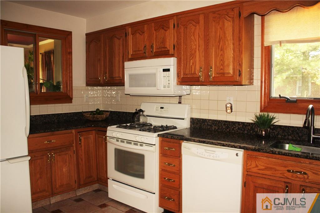 595 Old Post Road Edison, NJ 08817 - Photo 10 of 19 a kitchen with granite countertop a stove sink and cabinets