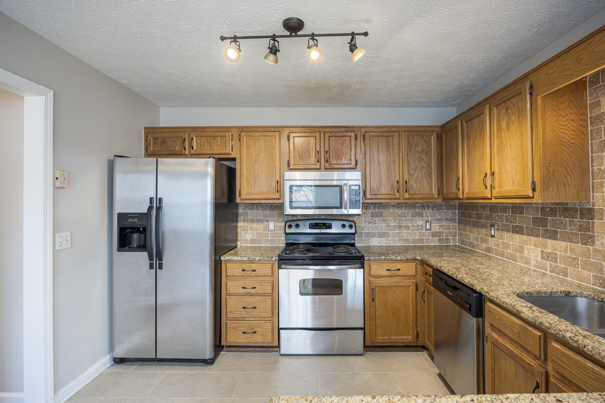 5916 Retriever Court Antioch, TN 37013 - Photo 7 of 30 a kitchen with stainless steel appliances granite countertop a refrigerator stove and sink