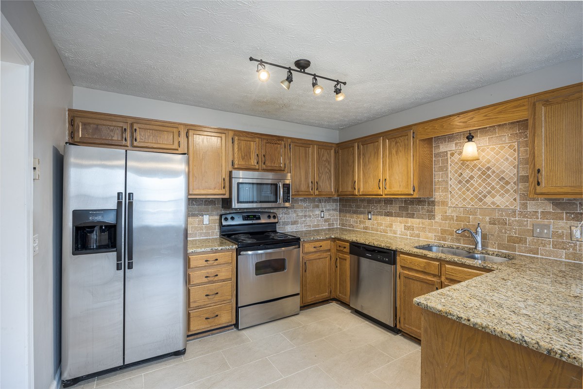5916 Retriever Court Antioch, TN 37013 - Photo 8 of 30 a kitchen with stainless steel appliances granite countertop a sink stove refrigerator and cabinets