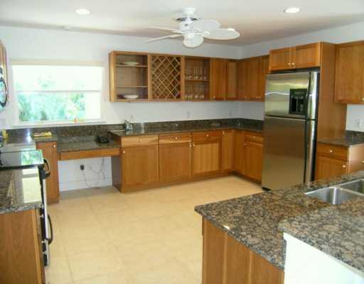 27 North River Road Stuart, FL 34996 - Photo 7 of 8 a kitchen with stainless steel appliances granite countertop a sink stove and refrigerator