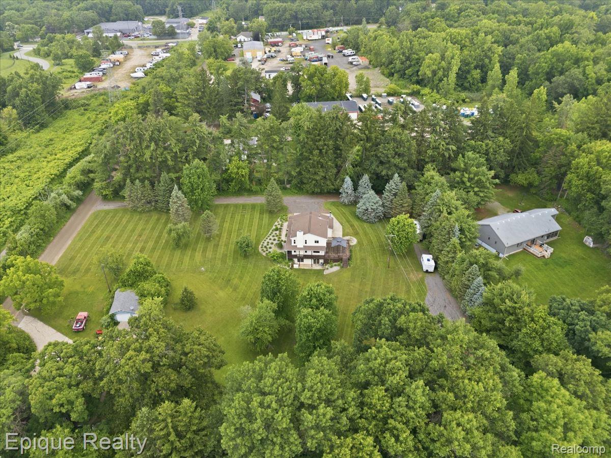 1221 Rhodes Road Lake Orion, MI 48360 - Photo 63 of 72 Expansive property featuring a multi-level residence, detached outbuilding, and gravel driveway