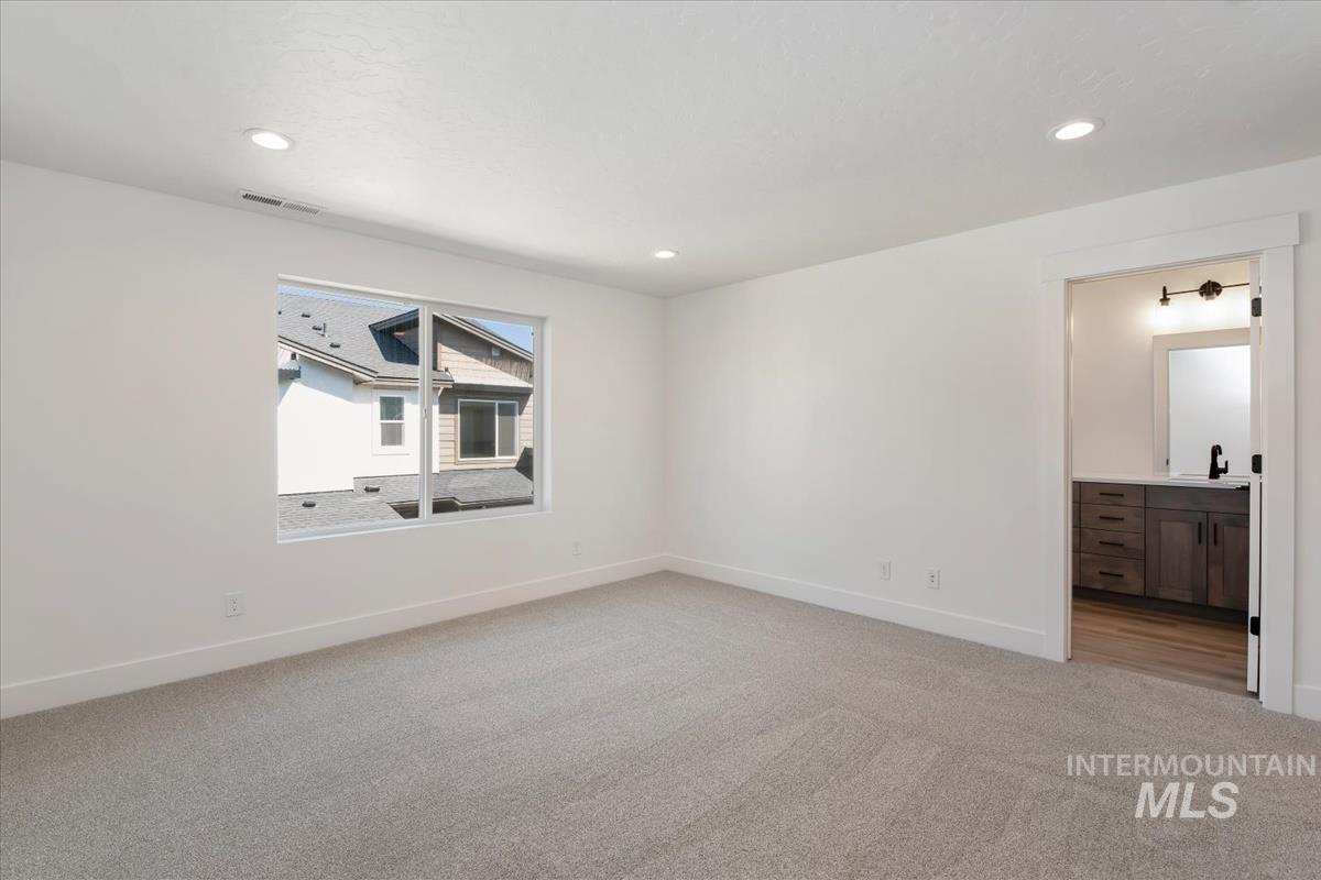 768 South Calhoun Lane Star, ID 83669 - Photo 20 of 36 Spacious room featuring light gray carpeting, recessed lighting, and a wide window