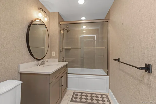 a bathroom with a sink a toilet and a mirror