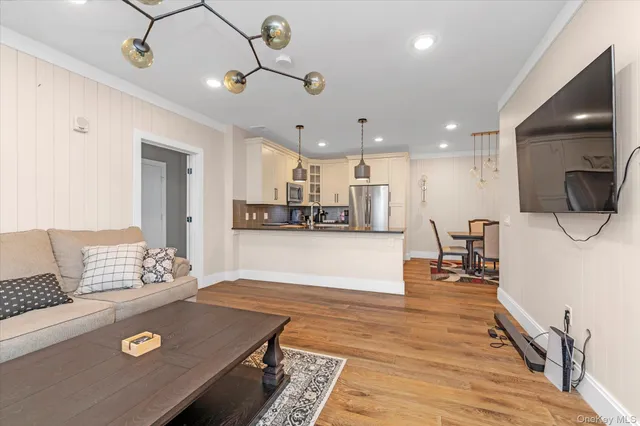 a living room with kitchen island furniture and a flat screen tv